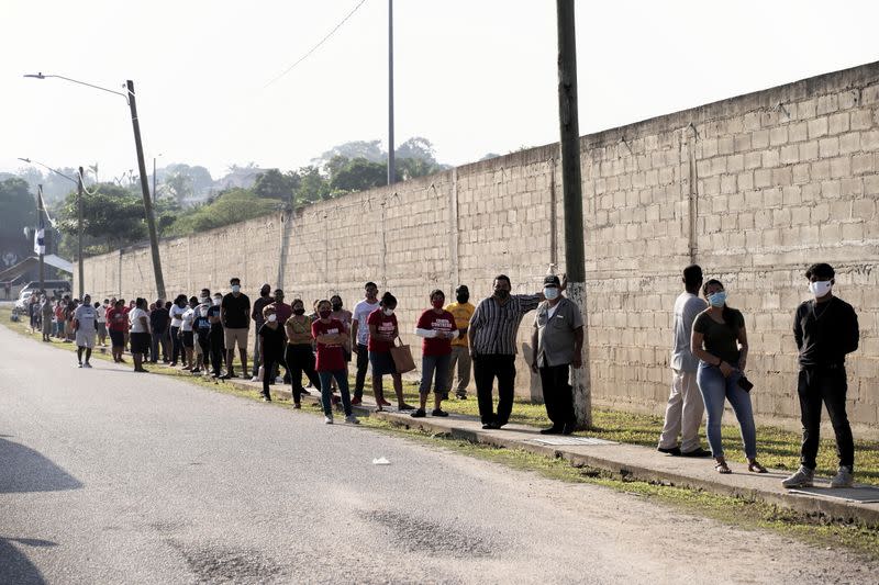 People queue outside a polling station to cast their vote during the election for a new prime minister, in Benque Viejo del Carmen