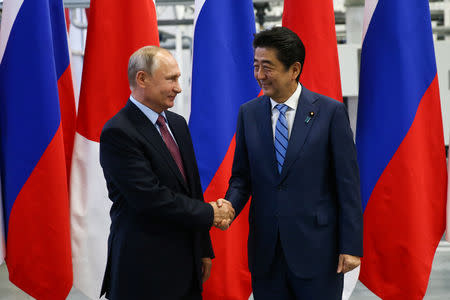 Russian President Vladimir Putin shakes hands with Japanese Prime Minister Shinzo Abe during their visit to the Mazda Sollers Manufacturing Rus joint venture plant of Sollers and Japanese Mazda in Vladivostok, Russia September 10, 2018. Valery Sharifulin/TASS Host Photo Agency/Pool via REUTERS/File Photo