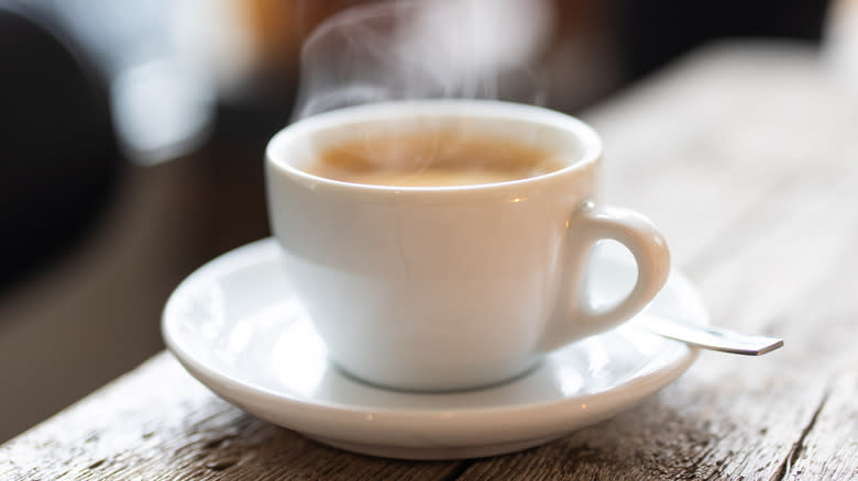 Hot steaming espresso on table