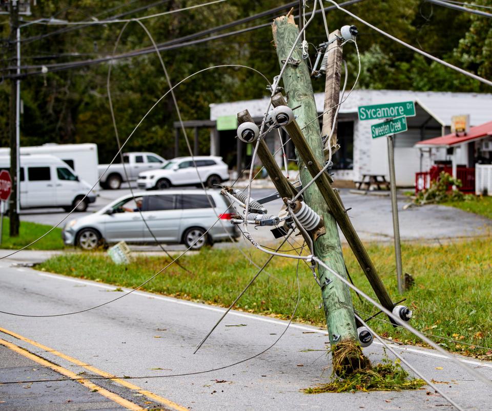 Downed power lines and poles line Sweeten Creek Road in Arden Friday afternoon after Hurricane Helene passed through the Asheville area the night before.