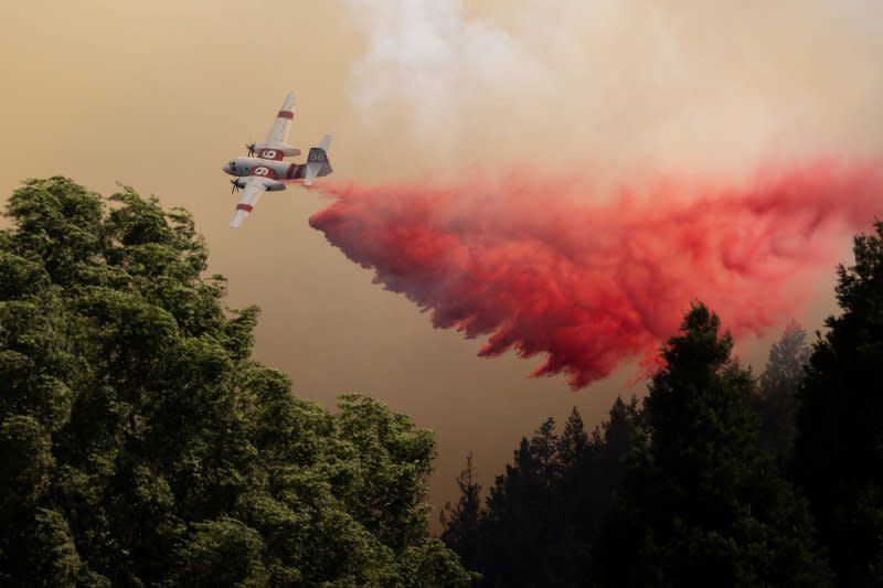 A plane drops retardant ahead of the Point Fire, west of Geyserville, Calif., on Sunday. Photo by Peter DaSilva/UPI