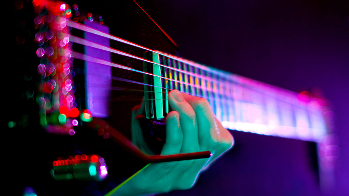  Close up of hand on electric guitar fretboard. 