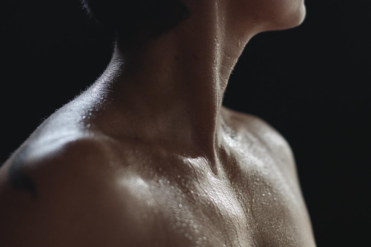 Person's chin and bare shoulders, covered in moisture.