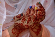 A woman, her hands decorated with traditional henna, prays during Eid al-Fitr prayer at historical Badshahi mosque in Lahore, Pakistan, Sunday, May 24, 2020. Millions of Muslims across the world are marking a muted and gloomy holiday of Eid al-Fitr, the end of the fasting month of Ramadan _a usually joyous three-day celebration that has been significantly toned down as coronavirus cases soar. (AP Photo/K.M. Chaudary)