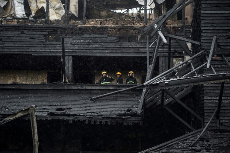 Firefighters survey the aftermath of the fire which gutted the famous hotel