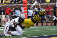 Michigan running back Hassan Haskins (25) dives into the end zone for a five-yard touchdown run against Northern Illinois in the first half of a NCAA college football game in Ann Arbor, Mich., Saturday, Sept. 18, 2021. (AP Photo/Paul Sancya)