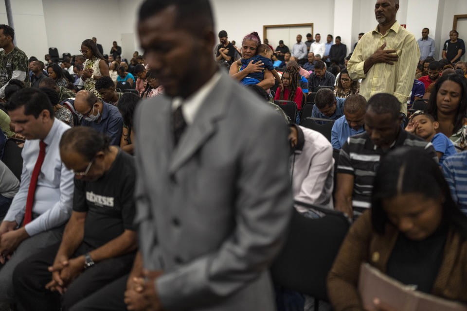 Evangelicals pray during a political rally promoting their choice of electoral candidates in the upcoming general election, at a convention hall in Salvador, Brazil, Saturday, Sept. 17, 2022. Both presidential candidates are Catholic, but incumbent President Jair Bolsonaro frames the race as a battle of good versus evil, with himself as God’s standard-bearer and front runner Luiz Inacio Lula da Silva, Brazil's former president, a devil. (AP Photo/Rodrigo Abd)