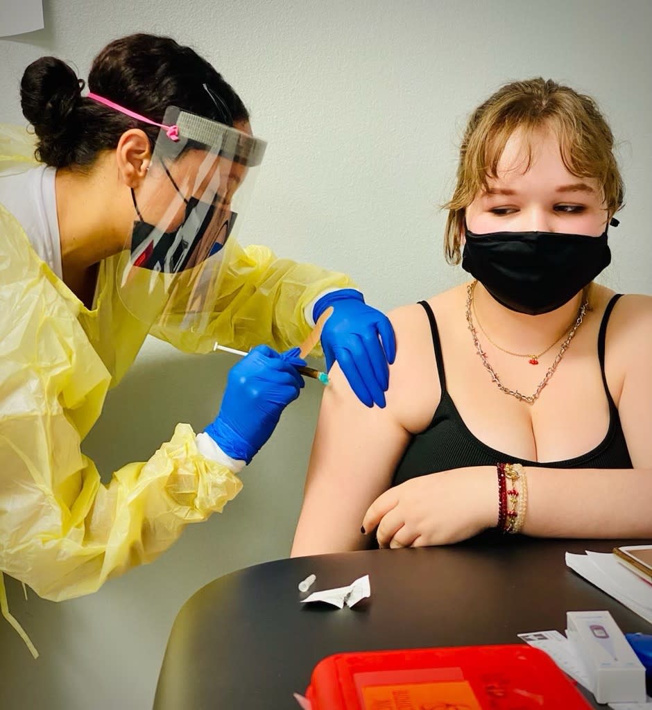 A teenage girl receives an injection during the Moderna trial.