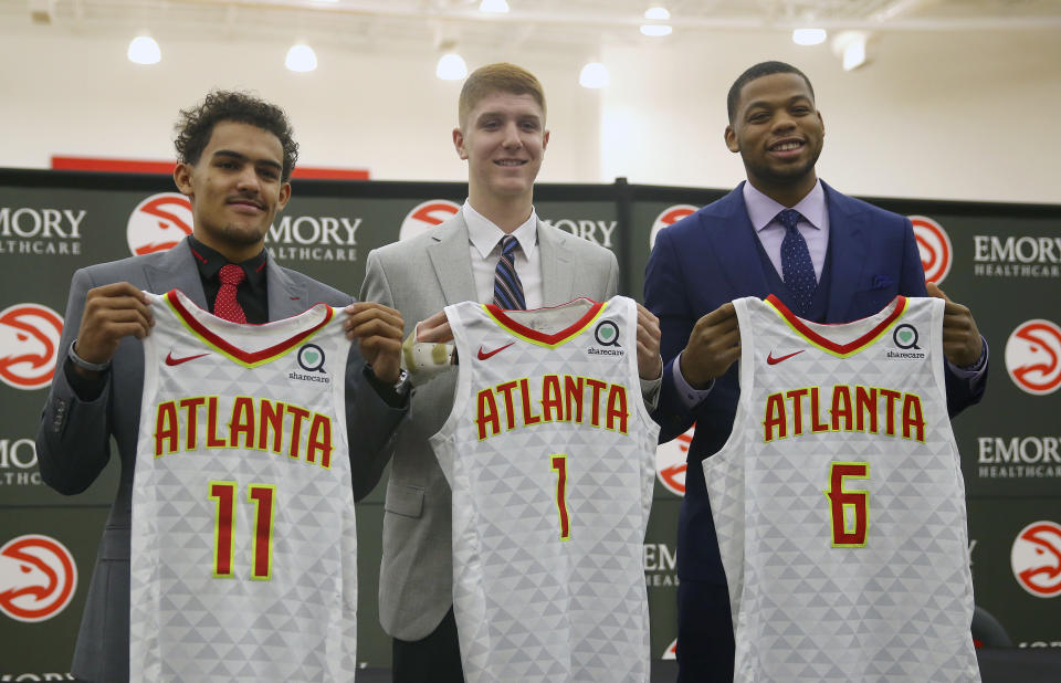 Atlanta Hawks NBA Draft first-round draft picks Trae Young (11), Kevin Huerter (1) and Omari Spellman (6) pose with their jerseys during a news conference Monday, June 25, 2018, in Atlanta.(AP photo/John Bazemore)