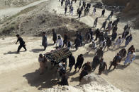 Men carry the coffin of a relative who died in Wednesday's deadly suicide bombing that targeted a training class in a private building in the Shiite neighborhood of Dasht-i Barcha, in western Kabul, Afghanistan, Thursday, Aug. 16, 2018. The Afghan authorities have revised the death toll from the previous day's horrific suicide bombing in a Shite area of Kabul to 34 killed. (AP Photo/Rahmat Gul)