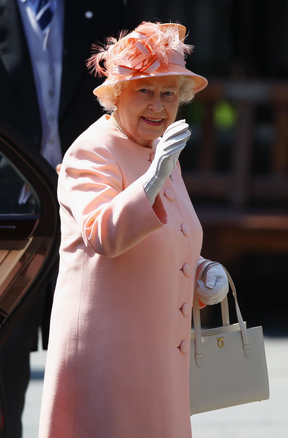 The Queen waves to watching crowds