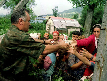 FILE PHOTO: Bosnian Serb wartime general Ratko Mladic hands out cans of beverages to refugees from Srebrenica in the village of Potocari, Bosnia and Herzegovina, July 12, 1995. REUTERS/Stringer/File Photo