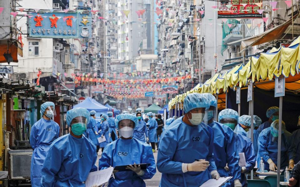 Health workers are seen in protective gear inside a locked down portion of the Jordan residential area to contain a new outbreak of the coronavirus in Hong Kong  - EUTERS/Tyrone Siu