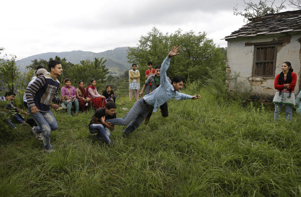 In this Aug. 25, 2012 photo, employees play a game of kabaddi as a team building exercise at the beginning of their working day near a B2R center in Simayal, India. (AP Photo/Saurabh Das)
