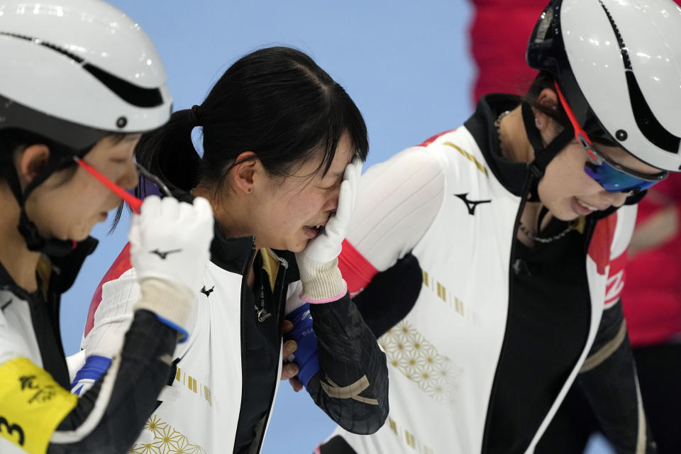 Nana Takagi of Team Japan is comforted by teammates after falling during the speedskating women's team pursuit finals at the 2022 Winter Olympics, Tuesday, Feb. 15, 2022, in Beijing. (AP Photo/Ashley Landis)