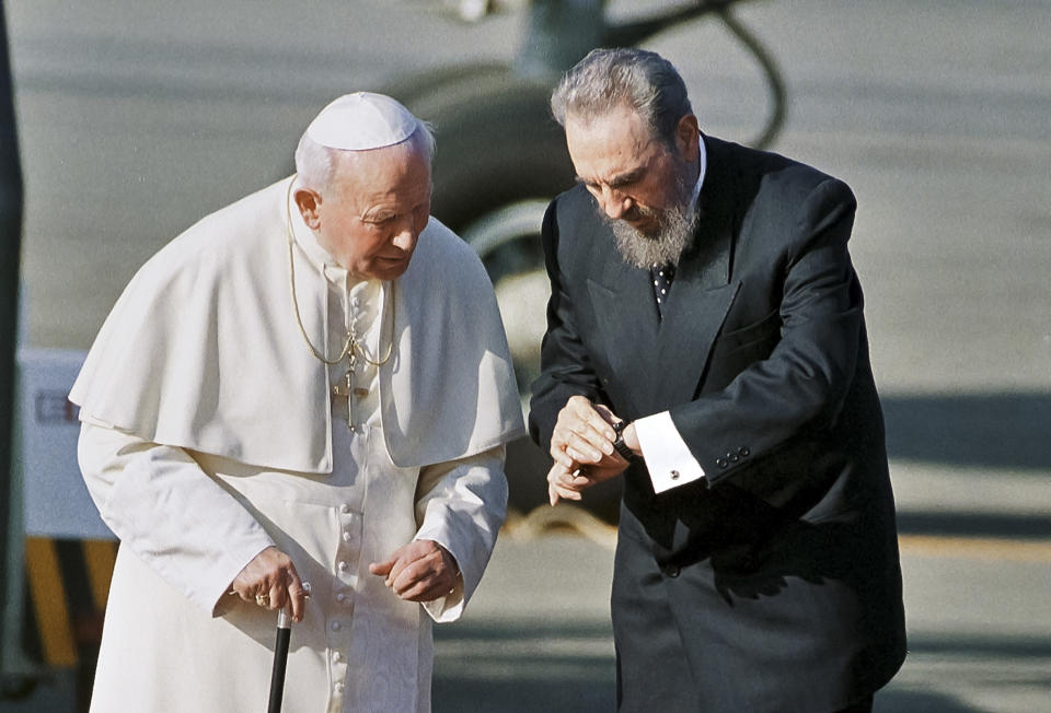 FILE - Cuba's President Fidel Castro, and Pope John Paul II, check the time during a welcoming ceremony in Havana, Cuba, June 21, 1998. The first papal visit to the island in 1998 marked a turning point that led to government acceptance of some outdoor religious events and the celebration of Christmas outside churches for the first time in more than three decades. (AP Photo/Jose Goitia, File)