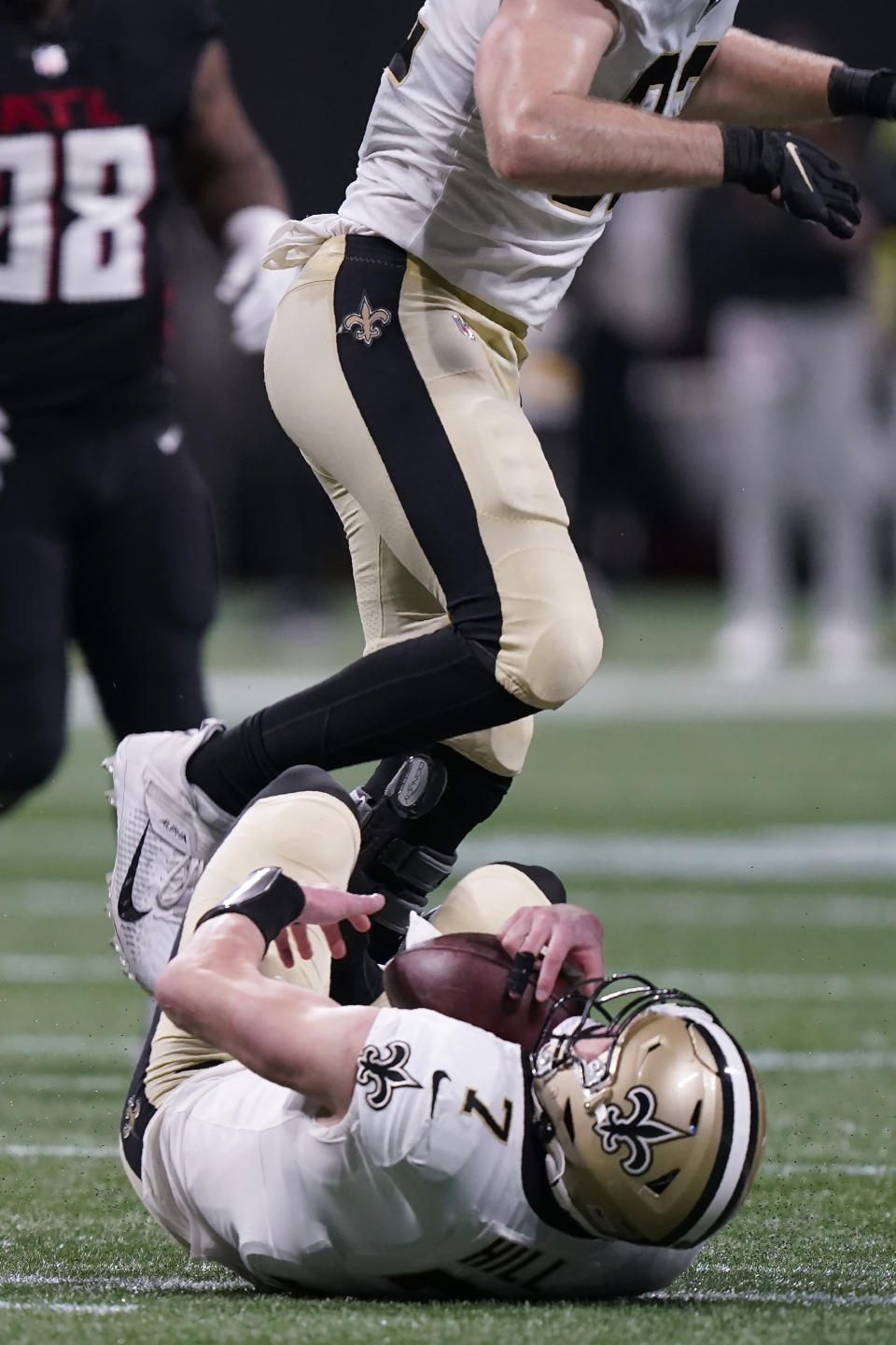 New Orleans Saints quarterback Taysom Hill (7) lies injured after a play against the Atlanta Falcons during the first half of an NFL football game, Sunday, Jan. 9, 2022, in Atlanta. Hill left the game due to injury. (AP Photo/Brynn Anderson)