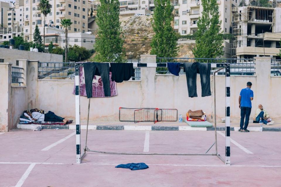 Clothes belonging to Palestinian workers from Gaza hang to dry on a soccer goal at the Redanna Sports Complex in the West Bank city of Ramallah on Oct. 14. This sports complex has been transformed into a refuge for over 450 Palestinian laborers from Gaza who were trapped inside Israel on Oct. 7. <span class="copyright">Maen Hammad</span>