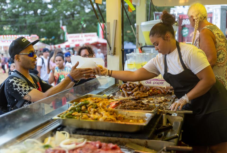 Keilanah Afrono, 16, hands over a steak sandwich to Lawrence Lewis, of Hyannis, at Kids’ Meals kitchen on Monday at the Barnstable County Fair in East Falmouth. Afrono is the niece of the owner, Raymond Hashem.