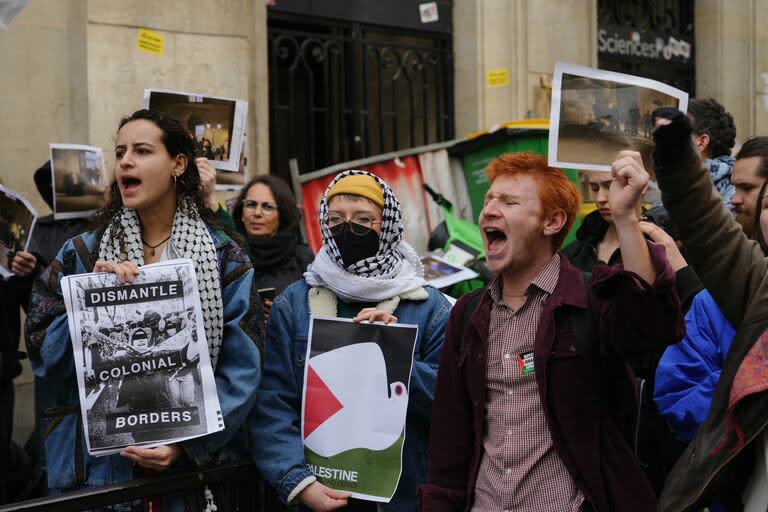 Los manifestantes sostienen carteles que dicen 