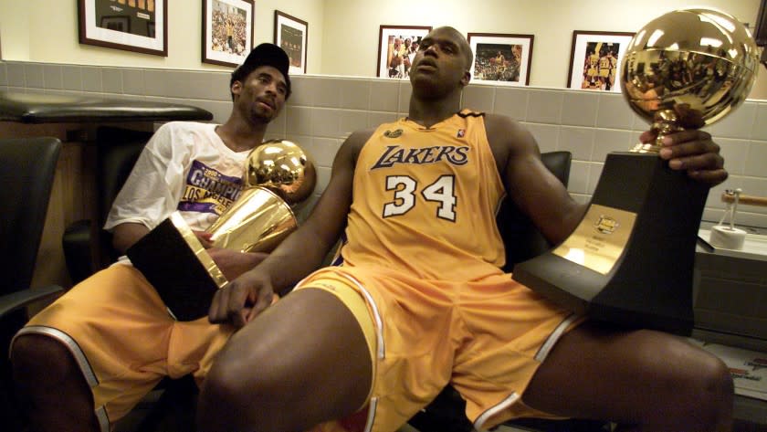 Lakers stars Kobe Bryant, left, and Shaquille O'Neal hold the championship trophies after winning Game 6 of the 2000 NBA Finals against the Indiana Pacers.