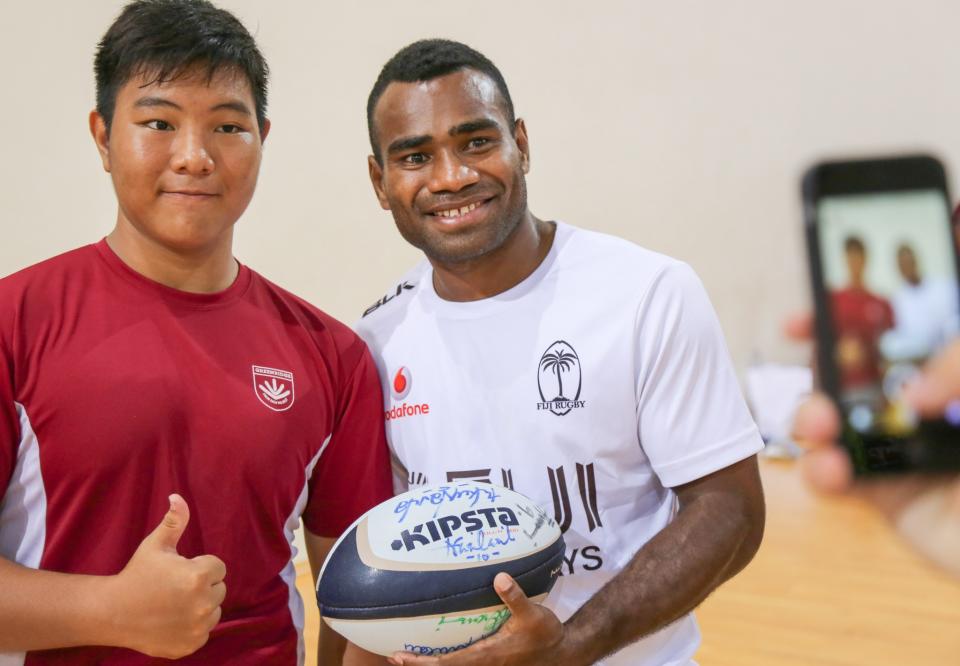 Jerry Tuwai poses for a photo with a fan after a rugby clinic at the OCBC Arena on Wednesday (12 April).