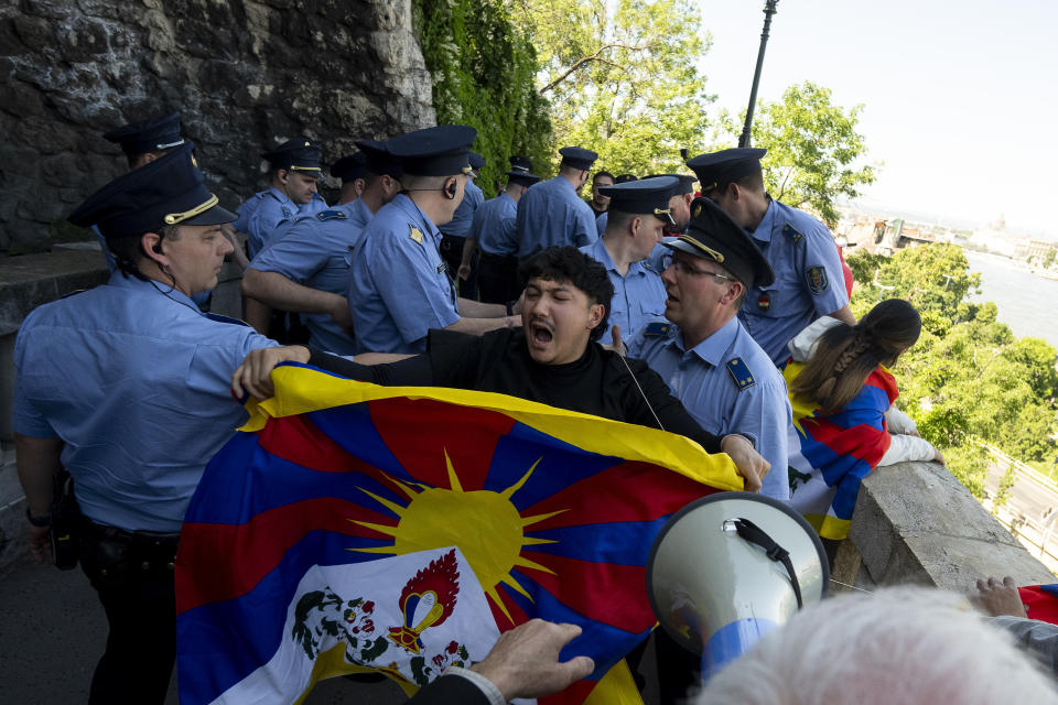 A Tibetan protester shouts surrounded by Hungarian police next to a Tibetan flag in Gellert Hill against Chinese President Xi Jinping's visit to Budapest, Hungary on Thursday, May 9, 2024. (AP Photo/Denes Erdos)