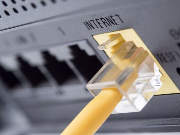 Close-up of an ethernet cord plugged into a router.