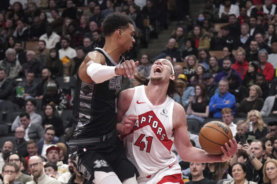 Toronto Raptors forward Kelly Olynyk (41) is fouled by San Antonio Spurs' Victor Wembanyama, left, during second-half NBA basketball game action in Toronto, Monday Feb. 12, 2024. (Chris Young/The Canadian Press via AP)