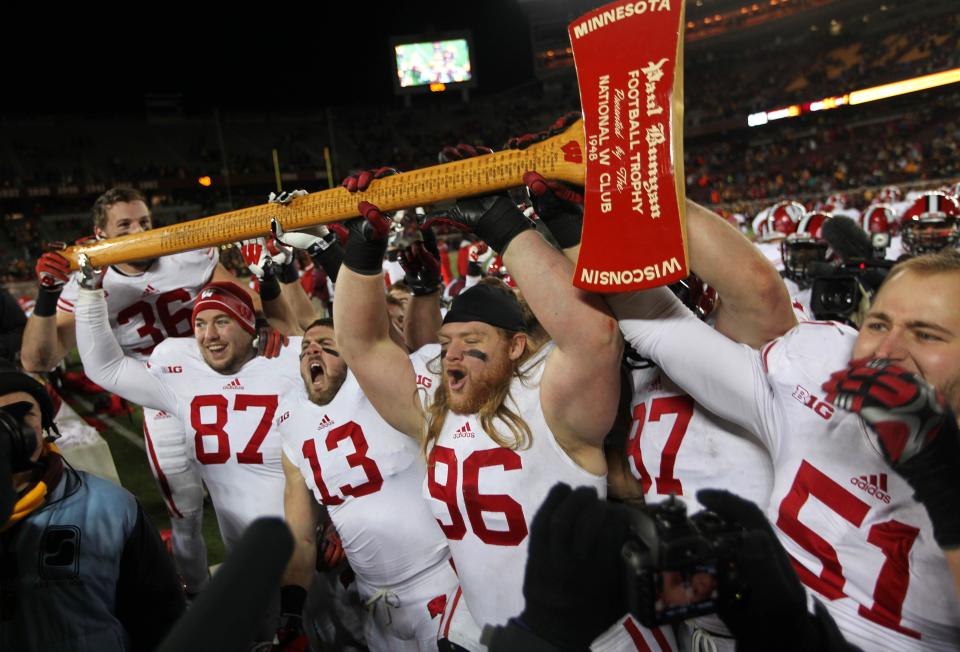 Wisconsin Badgers football players hoist the Paul Bunyan Ax after their victory during Wisconsin's 20-7 win over Minnesota at TCF Bank Stadium in Minneapolis, Minnesota, Saturday, Nov. 23, 2013. Minnesota has won the last two games in the series.