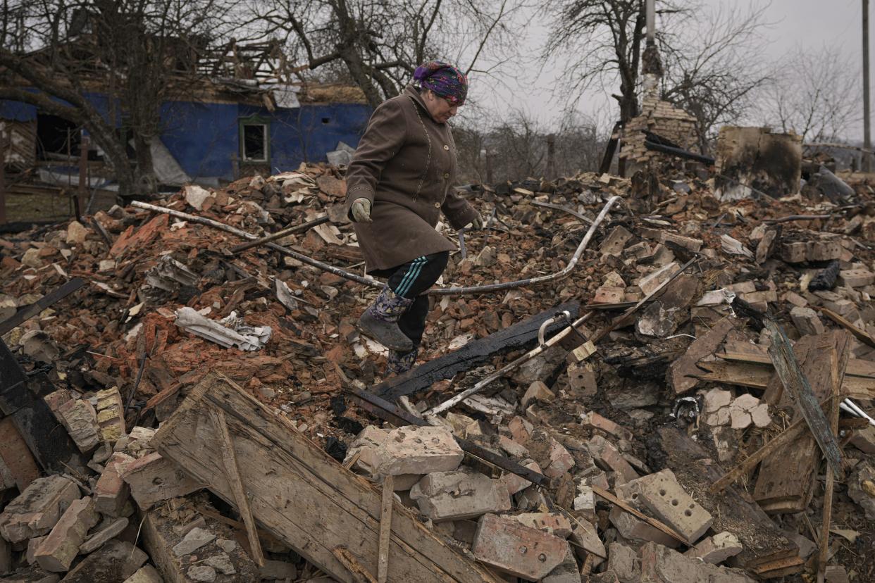 Mariya, a local resident, looks for personal items in the rubble of her house, destroyed during fighting between Russian and Ukrainian forces in the village of Yasnohorodka, on the outskirts of Kyiv, Ukraine, Wednesday, March 30, 2022. 