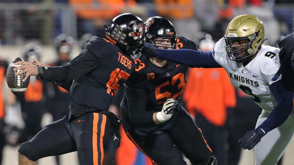 Hoban defensive end Jordan Pritchard-Sewell, right, yanks on the face mask of Massillon quarterback DaOne Owens on fourth down during the first half.