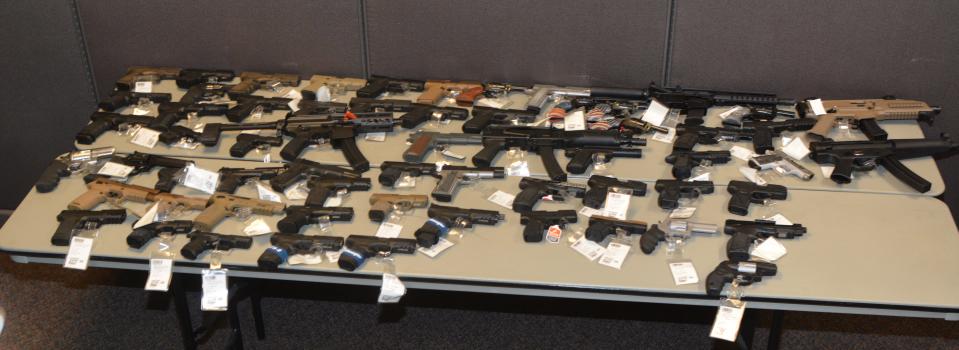 Some of the more than 60 guns stolen last year from a North Louisiana store found in Alexandria Thursday are displayed after they were found in a stolen vehicle left in the Christus St. Frances Cabrini parking garage.