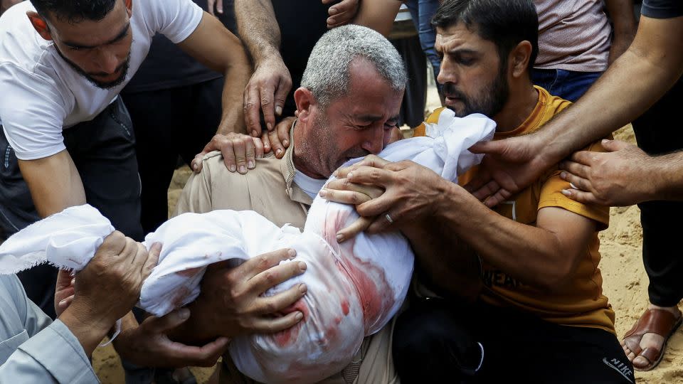 A mourner reacts while burying a child from who was killed in Israeli strikes in Khan Younis, Gaza, on October 11, 2023.  - Ibraheem Abu Mustafa/Reuters