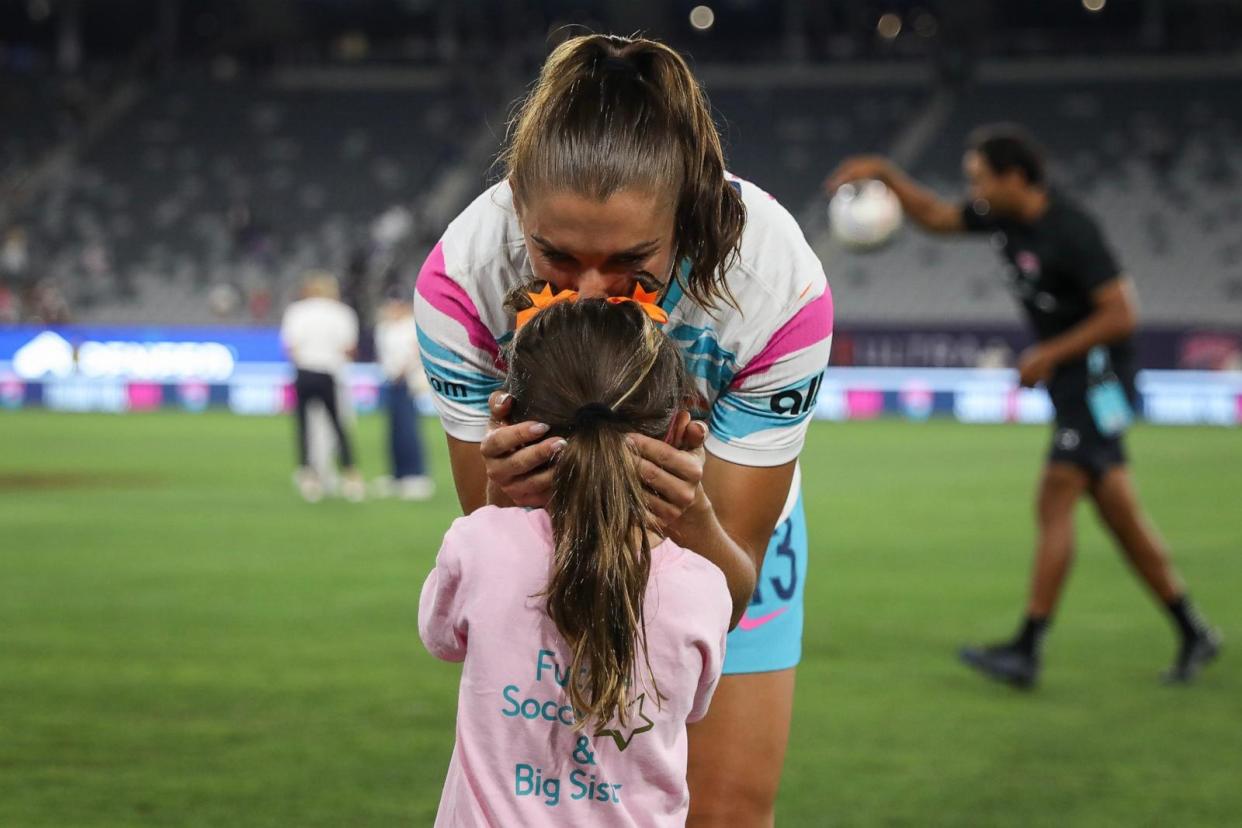 PHOTO: Alex Morgan of San Diego Wave FC kisses her daughter, Charlie, after the last match of her career Sept. 8, 2024, in San Diego. (Meg Oliphant/Getty Images)