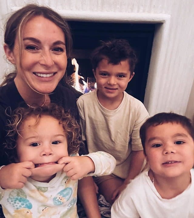 Alexa PenaVega and her two sons and one daughter smile for a photo