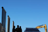 <p>Federal agents stand watch over President Donald Trump’s eight border wall prototypes as they near completion along U.S.- Mexico border near San Diego, Calif., Oct. 23, 2017. (Photo: Mike Blake/Reuters) </p>