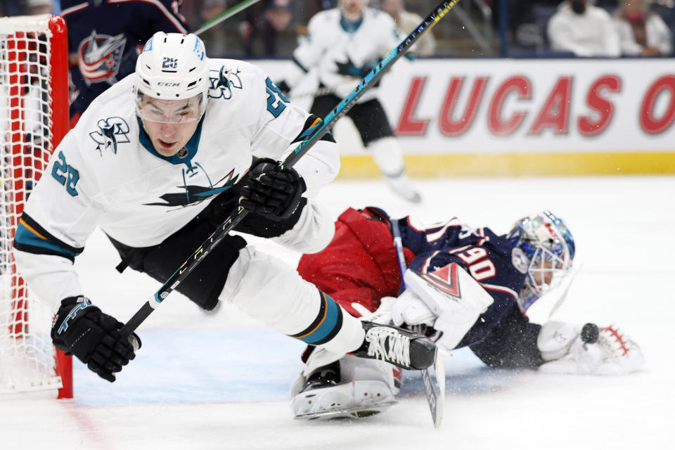 Columbus Blue Jackets' Elvis Merzlikins, right, makes a save as San Jose Sharks' Timo Meier trips during the first period of an NHL hockey game Sunday, Dec. 5, 2021, in Columbus, Ohio. (AP Photo/Jay LaPrete)