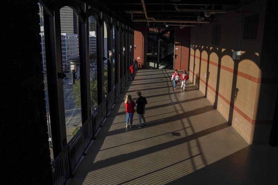 Fans arrive to Busch Stadium for Game 1 of the National League Championship Series baseball game between the St. Louis Cardinals and the Washington Nationals Friday, Oct. 11, 2019, in St. Louis. (AP Photo/Charlie Riedel)