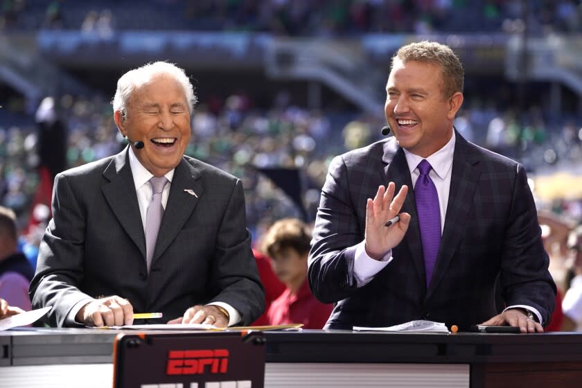 Kirk Herbstreit, right, shares a laugh with Lee Corso on the set of ESPN's College Game Day program in Soldier Field before an NCAA college football game between Wisconsin and Notre Dame Saturday, Sept. 25, 2021, in Chicago. (AP Photo/Charles Rex Arbogast)