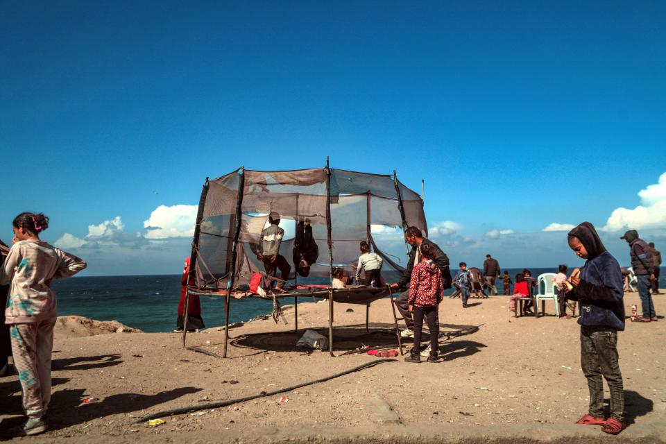 Palestinian children displaced with their families from Rafah play next the beach in Deir Al Balah, southern Gaza Strip, 14 February 2024 (EPA)