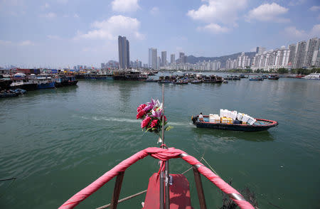 A boat sails past anchored boats at a fishing harbour, as Typhoon Mangkhut approaches, in Shenzhen, China September 15, 2018. REUTERS/Jason Lee