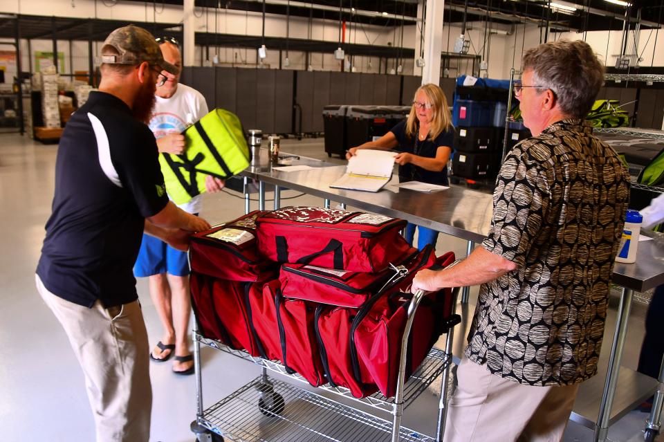 Election workers at the Elections Support Center in Melbourne were busy Monday as poll workers picked up ballots and election day supplies. 