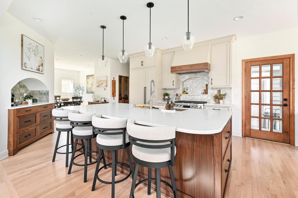 Kowalske Kitchen & Bath remodeled the first floor of a Brookfield home that is part of the 2024 NARI Milwaukee Tour of Remodeled Homes. The company created an open, family-friendly kitchen for a couple who loves to entertain. A large walnut island provides seating for the family and guests, and a built-in coffee bar adds warmth and complements the taupe cabinets along the range wall. To create the open concept, an existing wall between the kitchen and dining room was removed, which also brought more natural light into the space. Functional elements include deep drawers, a Galley workstation sink and walk-in pantry. Beautiful design elements make the kitchen shine, including a zellige tile backsplash, matte black hardware and walnut detail on the hood. The remodel also includes an updated laundry room, powder bathroom and fireplace.