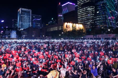 Demonstrators wave their smartphones during a rally ahead of the G20 summit, urging the international community to back their demands for the government to withdraw a the extradition bill in Hong Kong