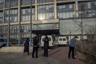A police officer chats with a man near police vehicles parked outside the headquarters of the Zhongzhi Enterprise Group Co. in Beijing, Monday, Jan. 8, 2024. A top executive of China Evergrande's electric vehicle company has been detained by police in the latest sign of trouble for the world's most heavily indebted property developer. That followed news over the weekend that Zhongzhi Enterprise Group, a major shadow bank in China that has lent billions in yuan (dollars) to property developers, filed for bankruptcy liquidation after it was unable to pay its debts. (AP Photo/Andy Wong)