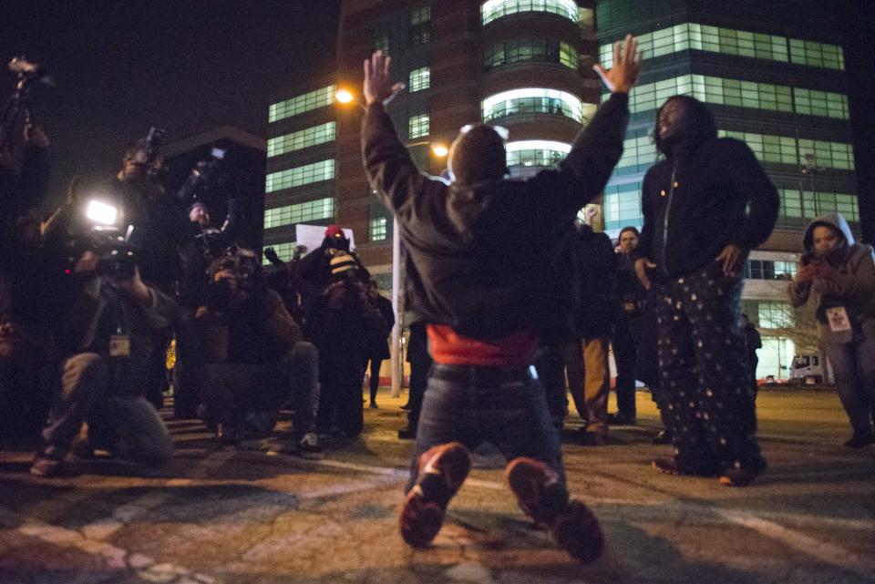 A protestor falls on his knees and chant "hands up don't shoot" after learning the grand jury announcement that officer Darren Wilson will not face criminal charges, in the August shooting of Michael Brown, outside St. Louis County Courthouse in Clayton