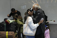 Members of the Mogul family, a father kisses his daughter, who arrived on a flight from Charlotte, North Carolina, in the U.S., at Terminal 5 of Heathrow Airport in London, Monday, Aug. 2, 2021. Travelers fully vaccinated against coronavirus from the United States and much of Europe were able to enter Britain without quarantining starting today, a move welcomed by Britain's ailing travel industry. (AP Photo/Matt Dunham)