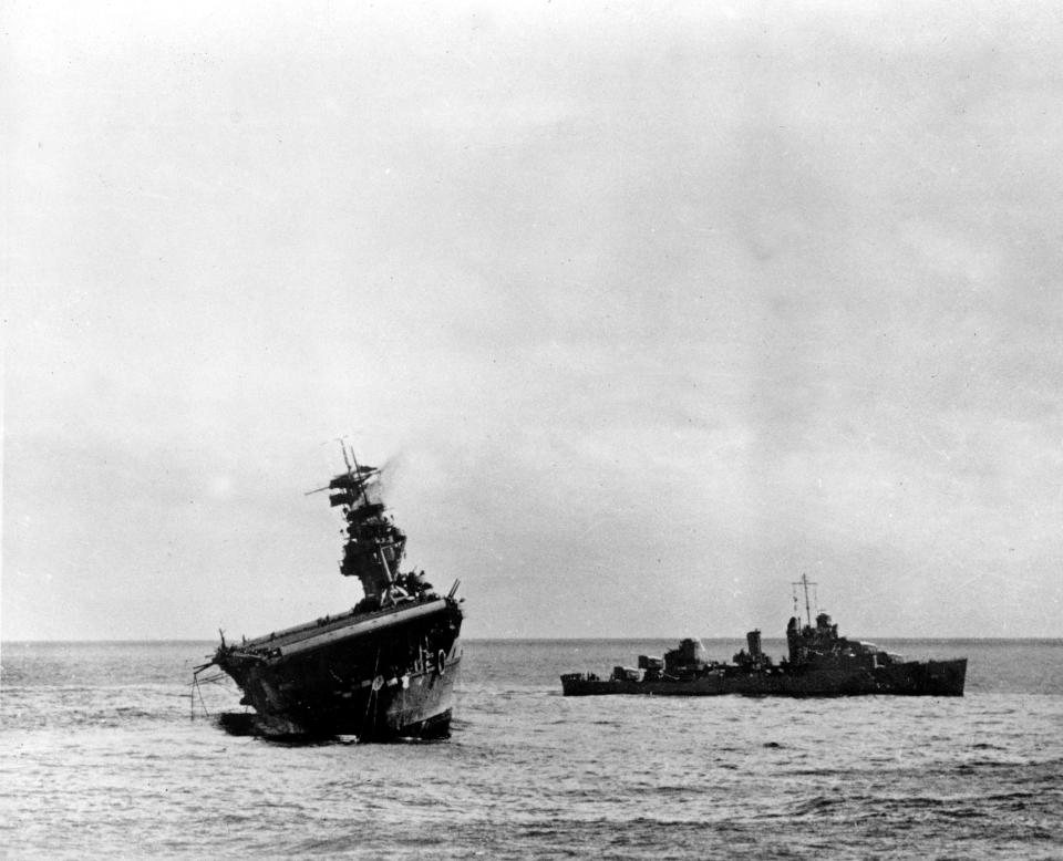 FILE - In this June 4, 1942 file photo provided by the U.S. Navy shows the USS Yorktown listing heavily to port after being struck by Japanese bombers and torpedo planes in the Battle of Midway. Researchers scouring the world's oceans for sunken World War II ships are honing in on debris fields deep in the Pacific. A research vessel called the Petrel is launching underwater robots about halfway between the U.S. and Japan in search of warships from the Battle of Midway. (AP Photo/U.S. Navy, File)