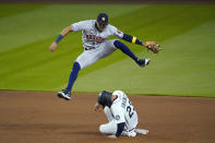 Houston Astros shortstop Carlos Correa leaps out of the way after forcing out Seattle Mariners' Ty France (23) at second base on a grounder from Kyle Lewis the fifth inning of a baseball game Tuesday, Sept. 22, 2020, in Seattle. (AP Photo/Elaine Thompson)